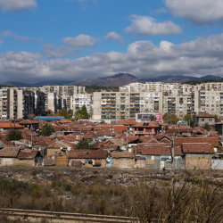 Беден цигански квартал, близо до Казанлък, на фона на "панелки" - жилищни панелни блокове.